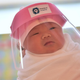 A photo of a newborn baby wearing a face shield, delivered at Praram 9 Hospital in Bangkok, Thailand on April 9, 2020.